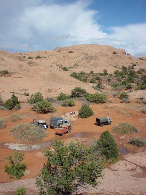 The trucks at the bottom of the sand hill.